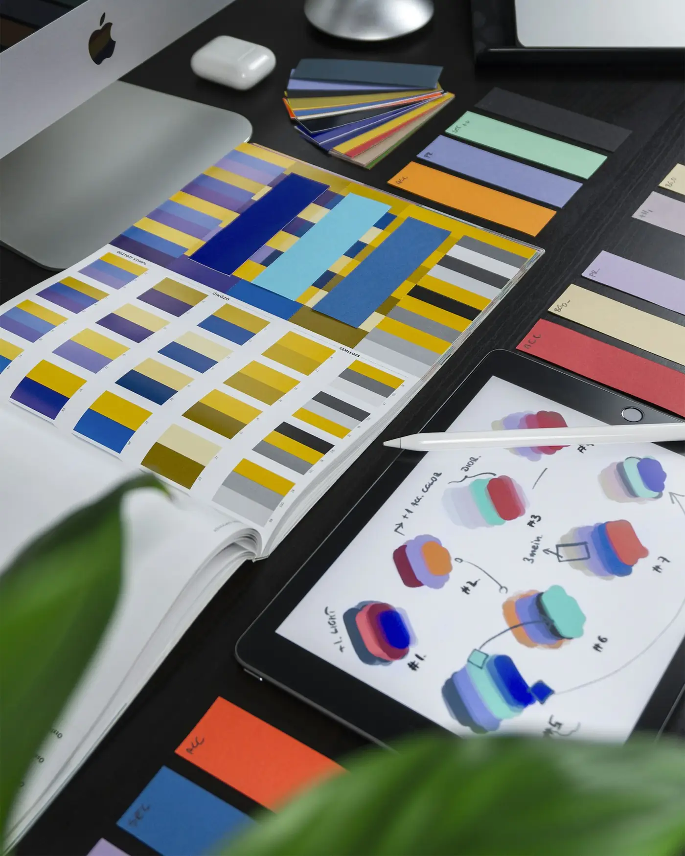 Printed brand color palettes and swatches arranged on a designer's desk